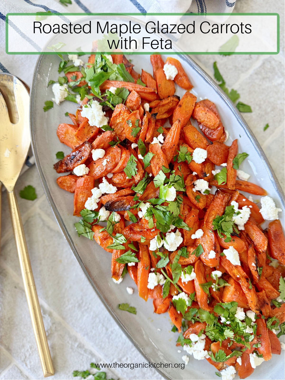 Roasted Maple Glazed Carrots with Feta garnished with cilantro on a gray plate with gold utensils to the left 