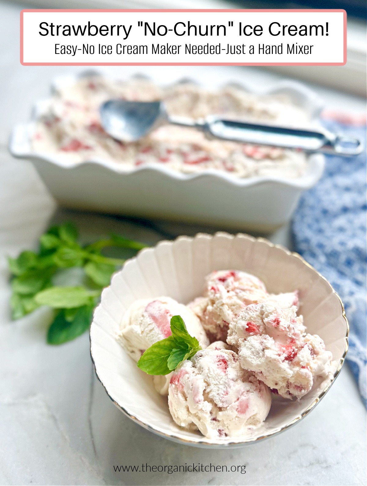 Three scoops of Strawberry "No Churn" Ice Cream garnished with mint leaves in a bowl with a dish of ice cream, a dish towel and mint leaves in background