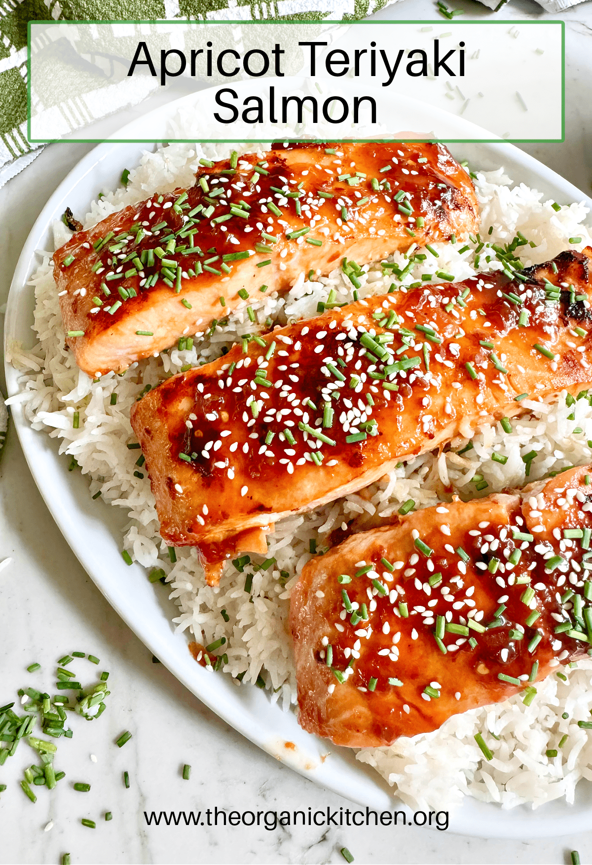 Three pieces of Apricot Teriyaki Salmon garnished with chives on white rice served on white plate