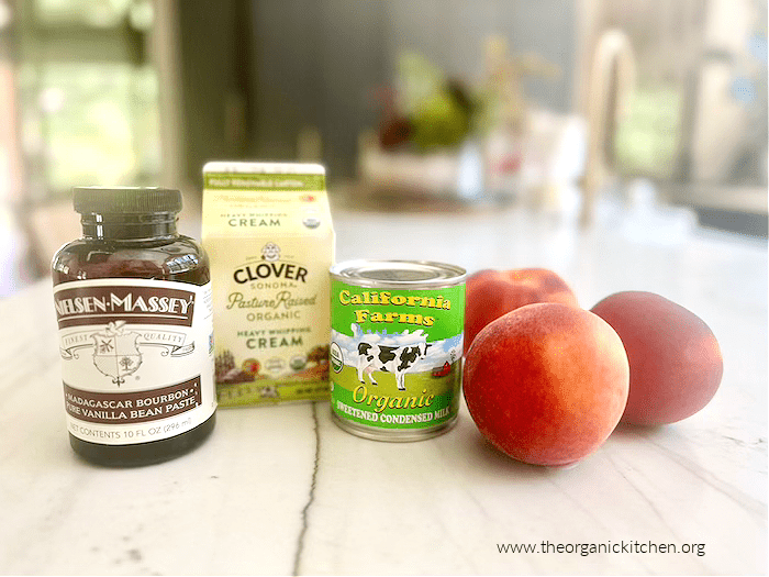 Ingredients for Fresh Peach "No Churn" Ice Cream: a bottle of vanilla paste, a pint of fresh cream, a can of sweetened condensed milk and three peaches