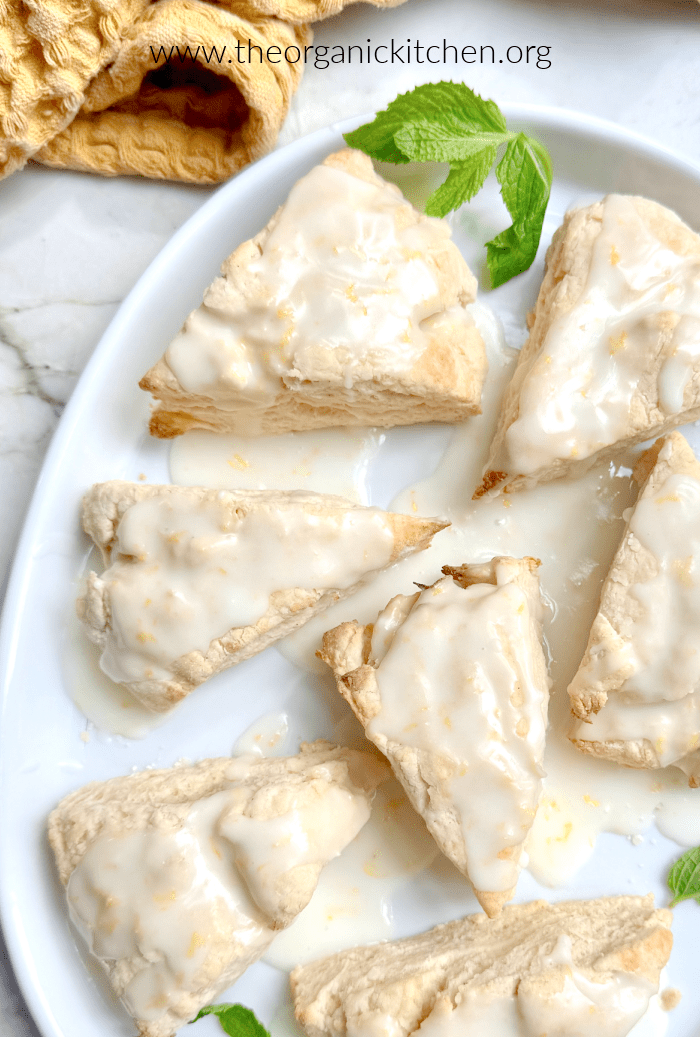 Vanilla Scones with Lemon Glaze garnished with mint on white plate