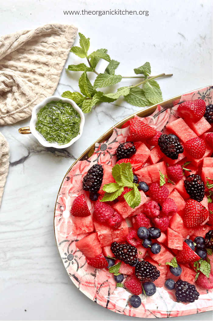 Watermelon Berry Salad with Honey Lime Dressing Watermelon Berry Salad with Honey Lime Dressing garnished with mint on a white marble counter