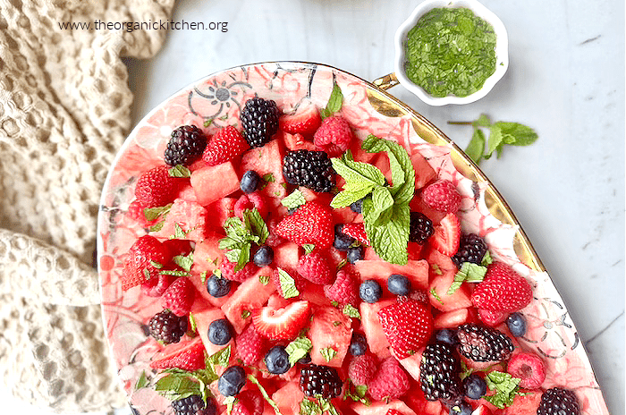Watermelon Berry Salad with Honey Lime Dressing Watermelon Berry Salad with Honey Lime Dressing on pink platter with small white bowl of mint