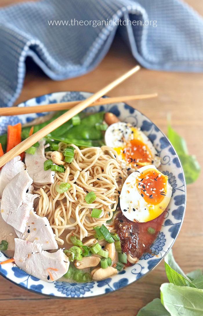 Easy Ramen with Chicken and Vegetables in blue and white bowl with blue dishtowel in background and chop sticks on the bowl