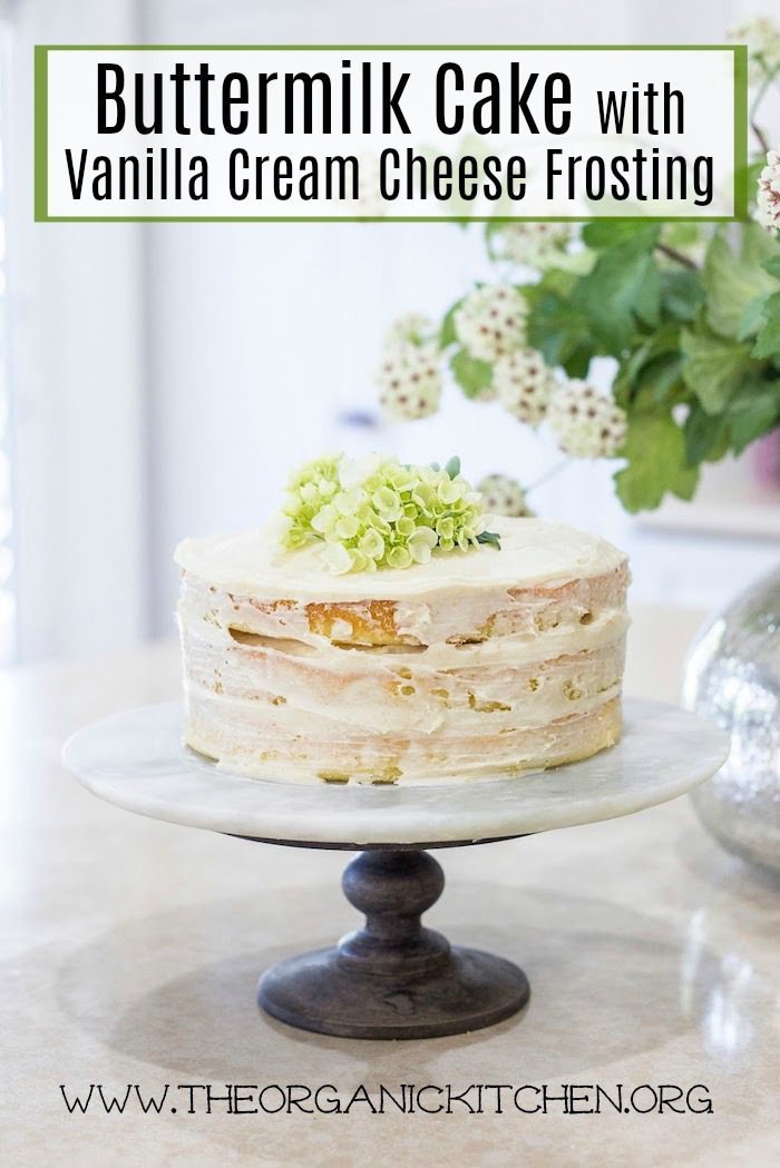 Buttermilk Cake with Vanilla Cream Frosting topped with hydrangea flowers on white cake plate