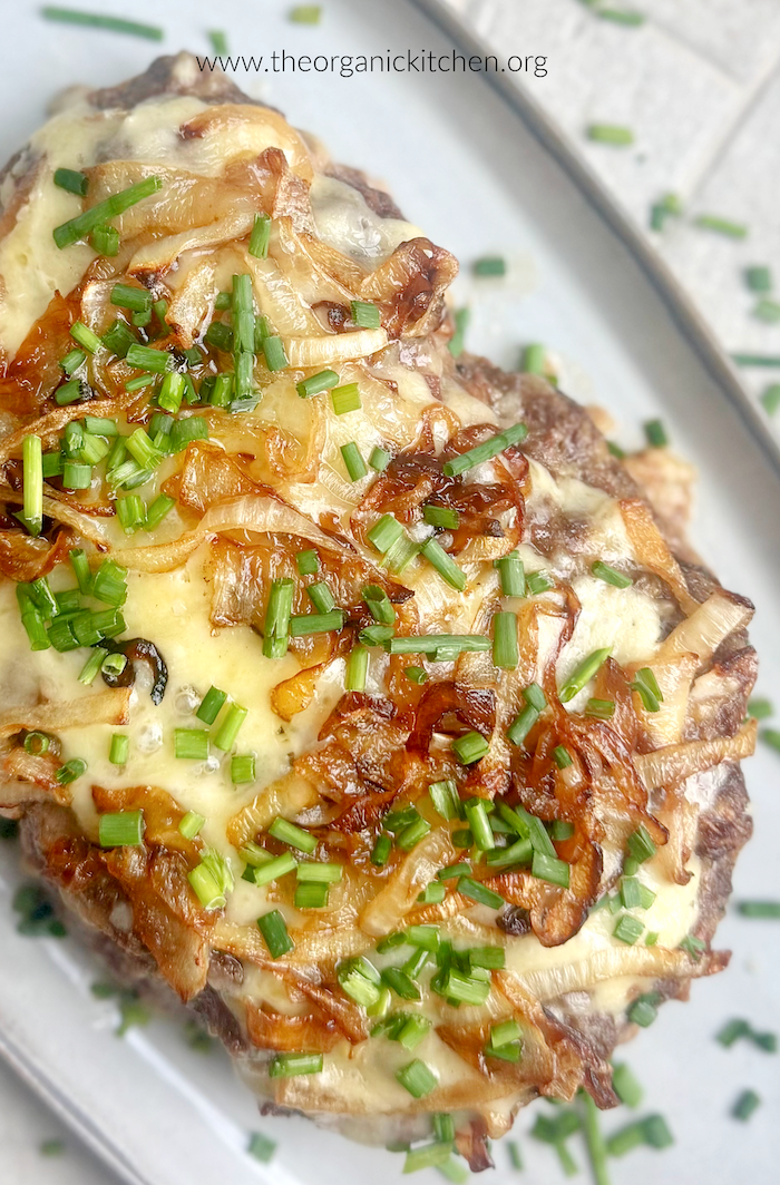 White Cheddar Meatloaf with Caramelized Onions garnished with chives on gray plate