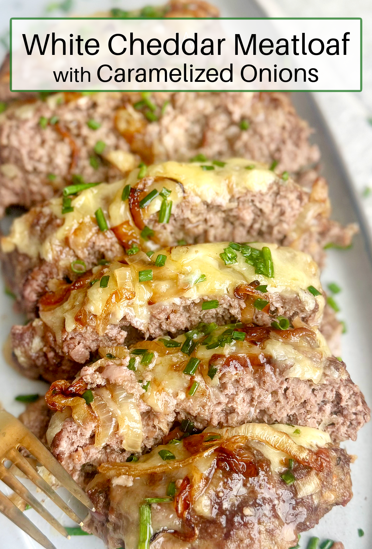 White Cheddar Meatloaf with Caramelized Onions garnished with chives on grey plate