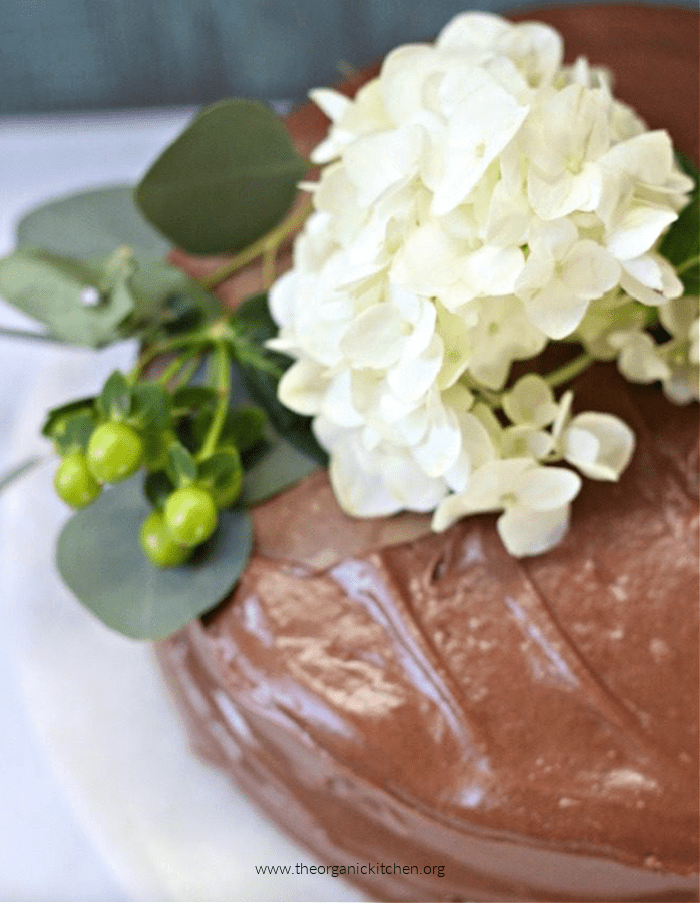 Classic Yellow Cake with Chocolate Frosting decorated with hydrangea flowers and leaves