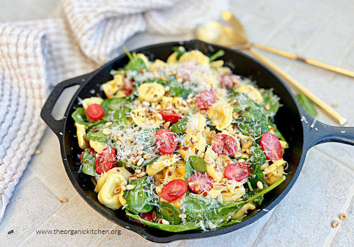 Easy Garlic Butter Tortellini Easy Garlic Butter Tortellini in black cast iron pan with dish towel and gold spoons in the backgrouns