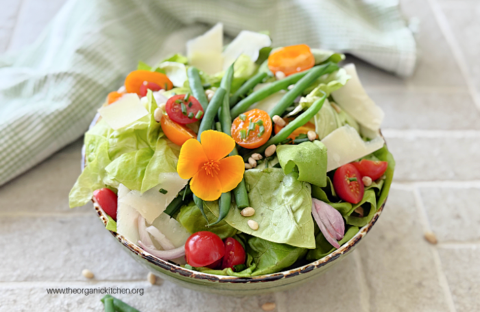 Green Bean and Tomato Salad Green Bean and Tomato Salad in green bowl on brick surface with green dish towel in background