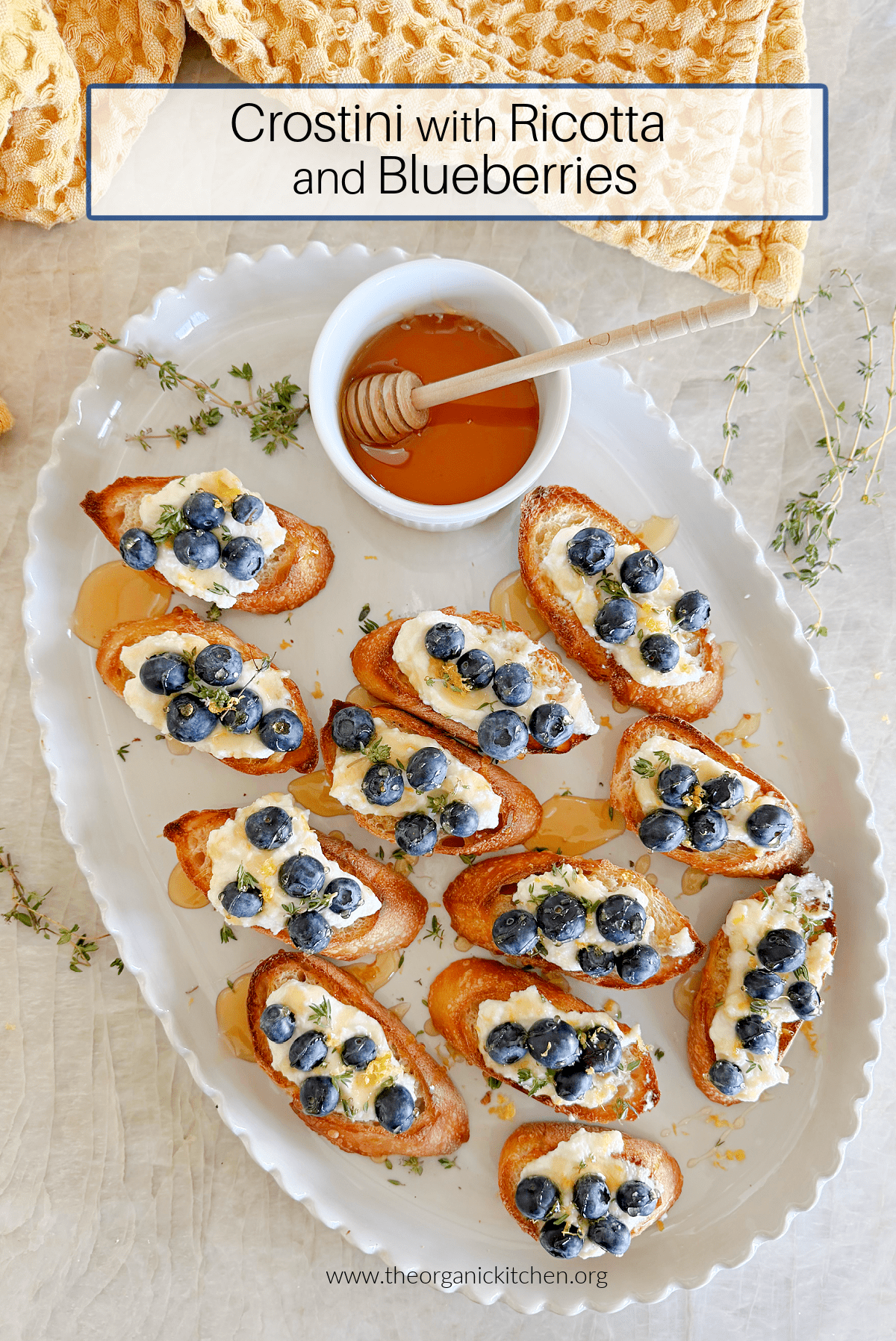 Crostini with Lemon Ricotta and Blueberries Crostini with Lemon Ricotta and Blueberries on white plate with a bowl of honey and yellow dish towel in background