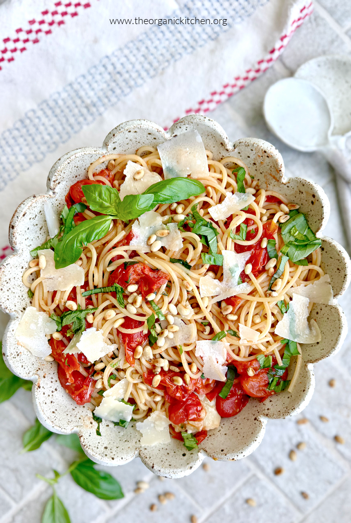 15 Recipes Using Cherry Tomatoes 15 Recipes Using Cherry Tomatoes: A bowl filled with pasta, tomatoes and basil garnisjed with parmesan and pine nuts with two serving spoons to the side