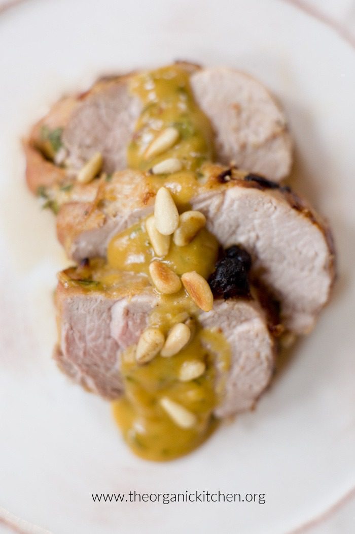 Sliced Pork Tenderloin with sauce on white plate