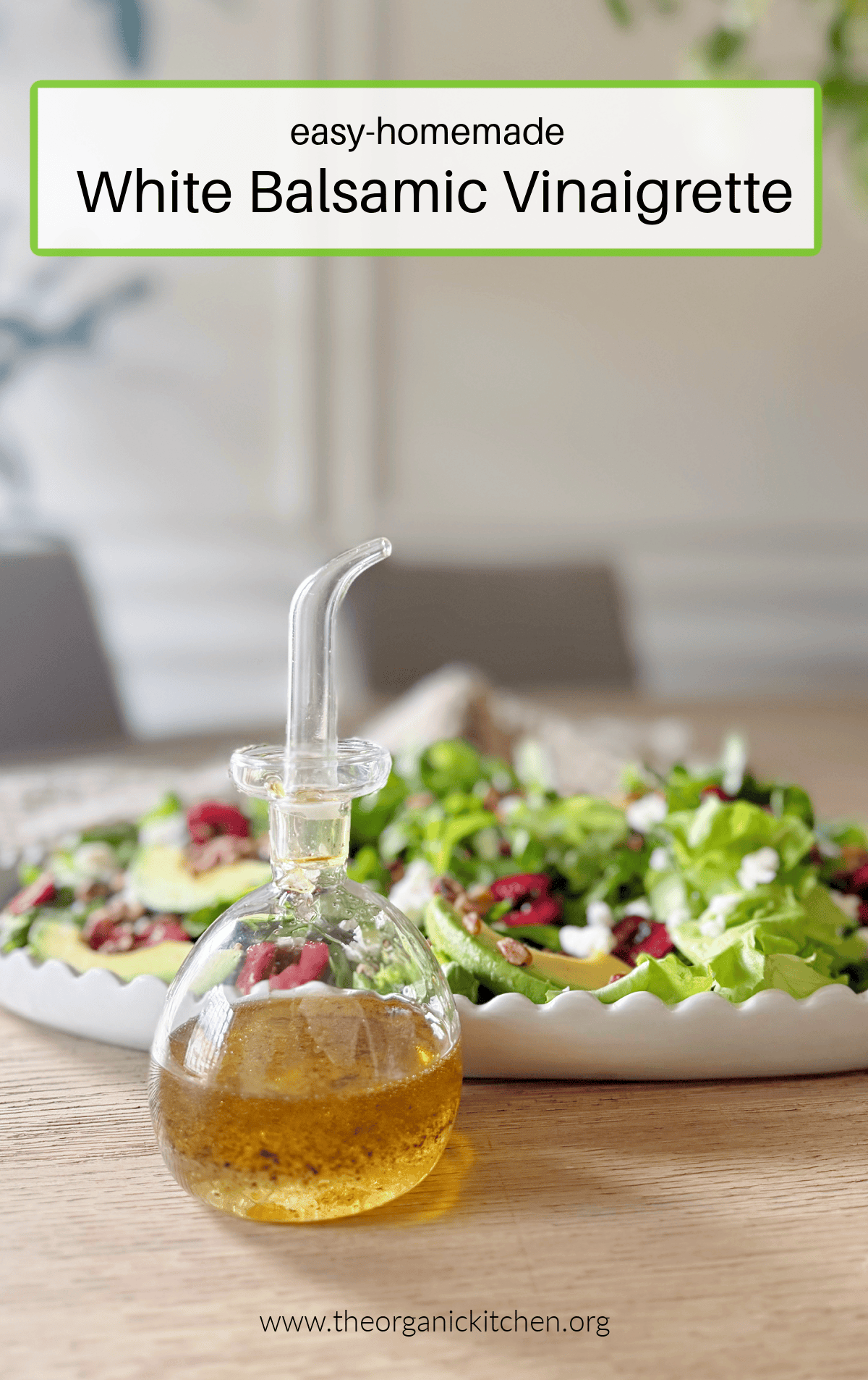 Easy White Balsamic Vinaigrette in a small glass bottle with a plate of green salad in the background