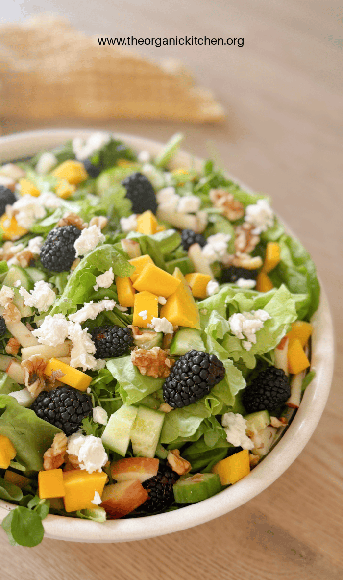 Blackberry Walnut Salad with Honey Vinaigrette, A white bowl overflowing with Blackberry Walnut Salad with Honey Vinaigrette, gold dish towel in the background