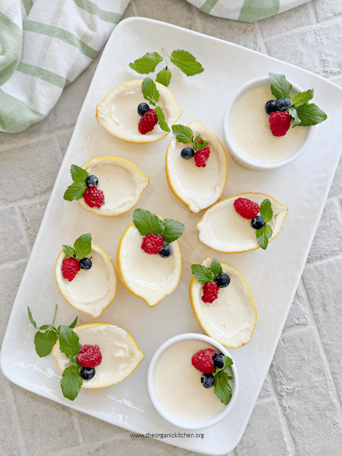 Easy Lemon Posset Easy Lemon Posset- a white tray with lemon halves and ramekins filled with lemon custard garnished with mint and berries