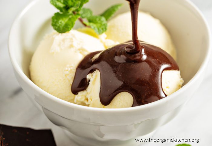 Classic Homemade Hot Fudge A while bowl with vanilla ice cream with Classic Homemade Hot Fudge and a mint sprig