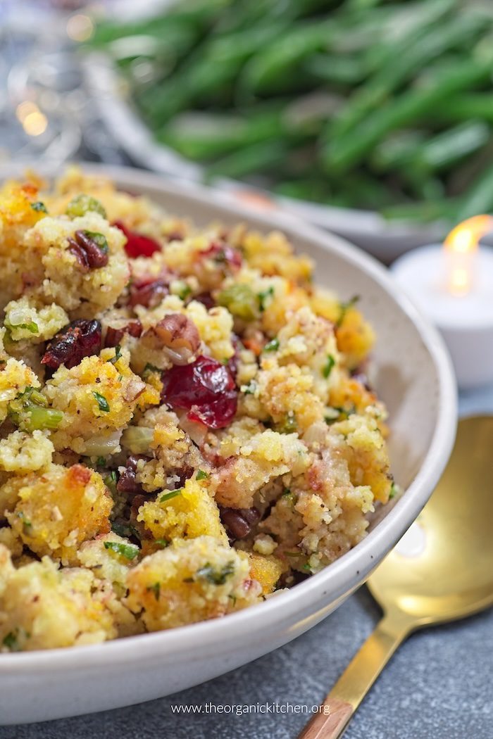 Delicious Buttery Herb Holiday Stuffing Delicious Buttery Herb Holiday Stuffing in a white ceramic bowl with green beans in the background