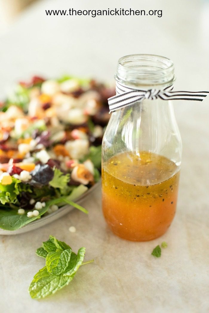 How to Make Delicious Salad Dressings at Home-Plus Recipes! A bottle of apple vinaigrette with a salad on a platter