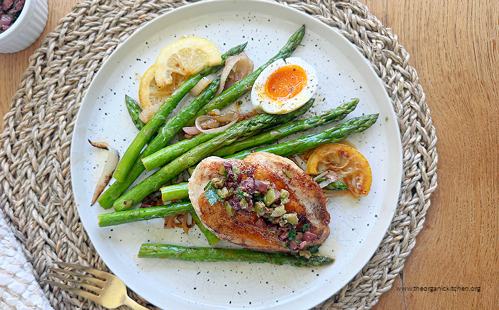 Mediterranean Chicken and Asparagus (Whole30)on white plate set on rattan place mat