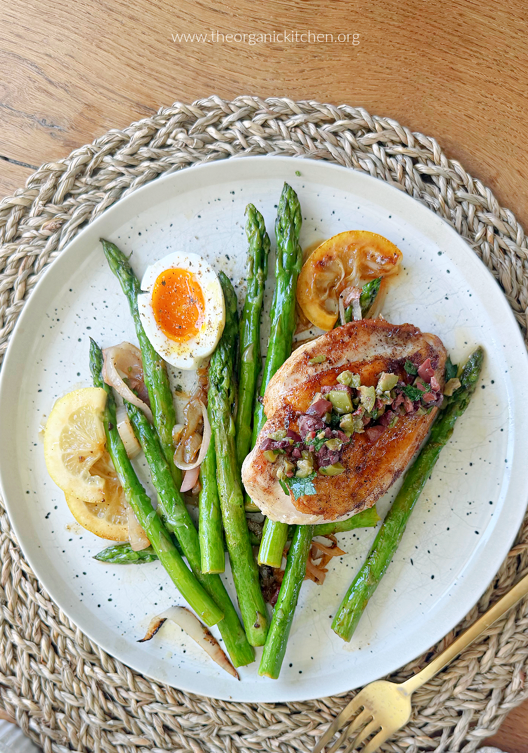 Mediterranean Chicken and Asparagus (Whole30) with lemon slices on white plate with gold fork 