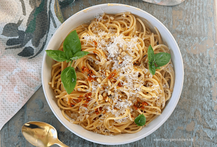 Easy Creamy Chili Oil Spaghetti Easy Creamy Chili Oil Spaghetti garnished with basil and pine nuts in white bowl on vintage blue table