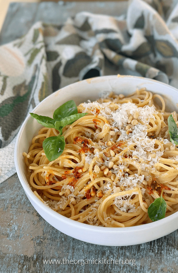 Easy Creamy Chili Oil Spaghetti Easy Creamy Chili Oil Spaghetti garnished with basil leaves and pine nuts on blue table