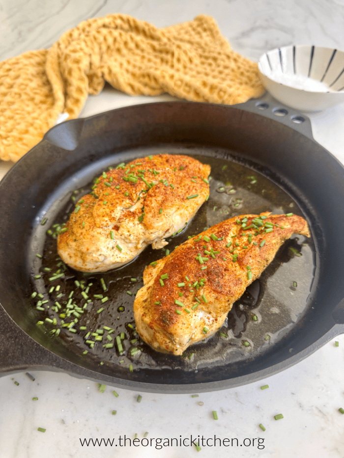 Two juicy chicken breasts in black cast iron skillet, as a part of 12 Delicious Chicken Breast Recipes