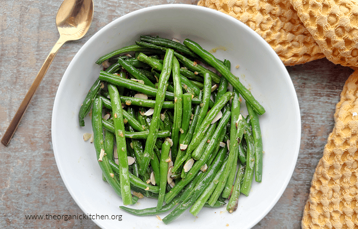 Copycat Din Tai Fung Green Beans garnished with almonds in white bowl