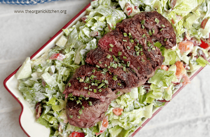 Filet Mignon with Chopped Salad on white plate with red trim